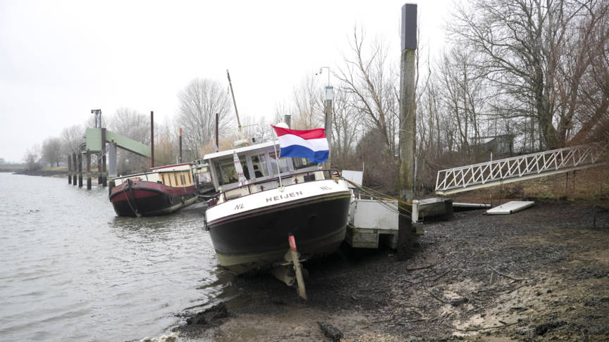 Scheefliggende woonboten op de maas vanwege het lage waterpijl